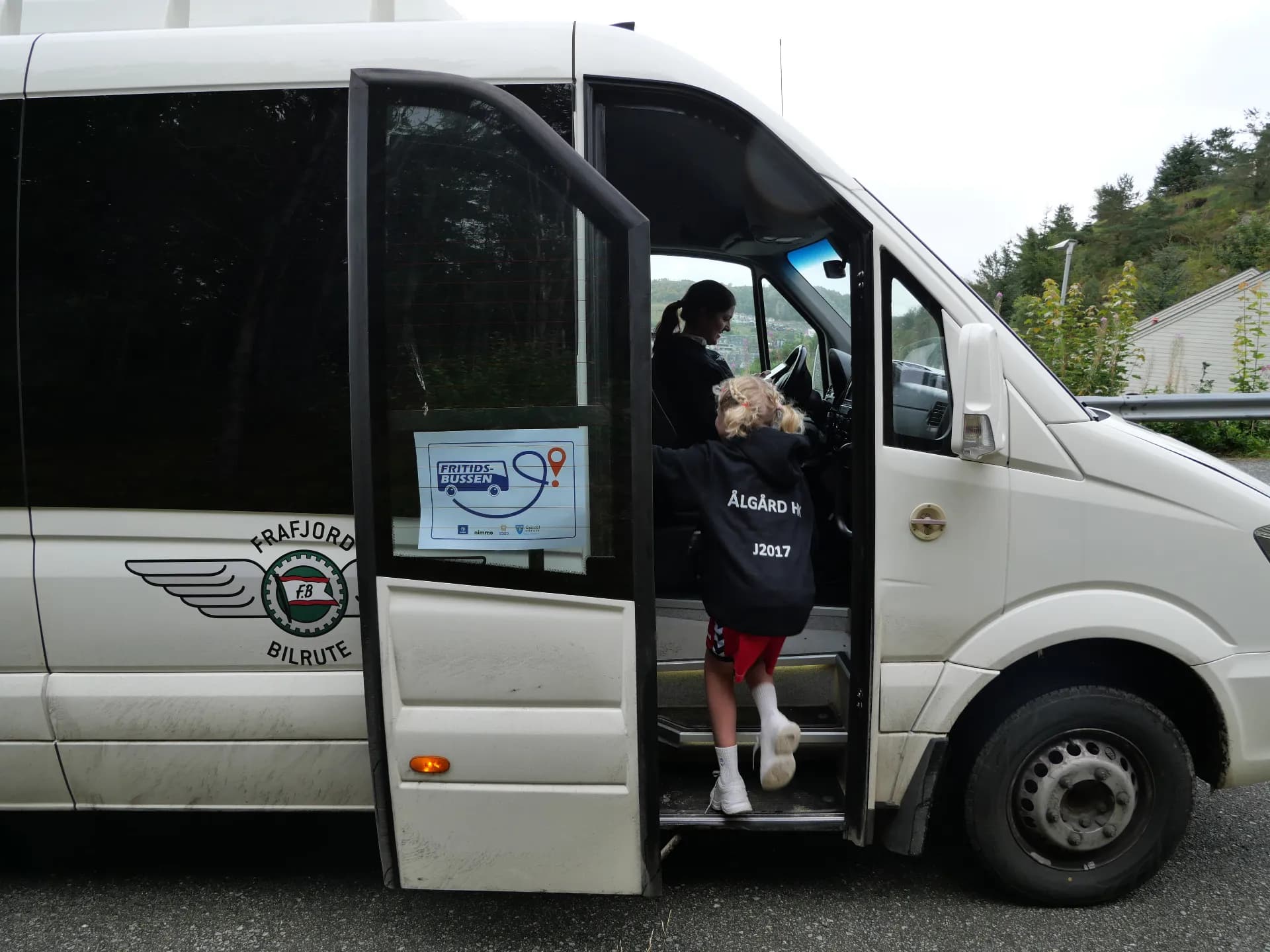 Jente går om bord i minibuss